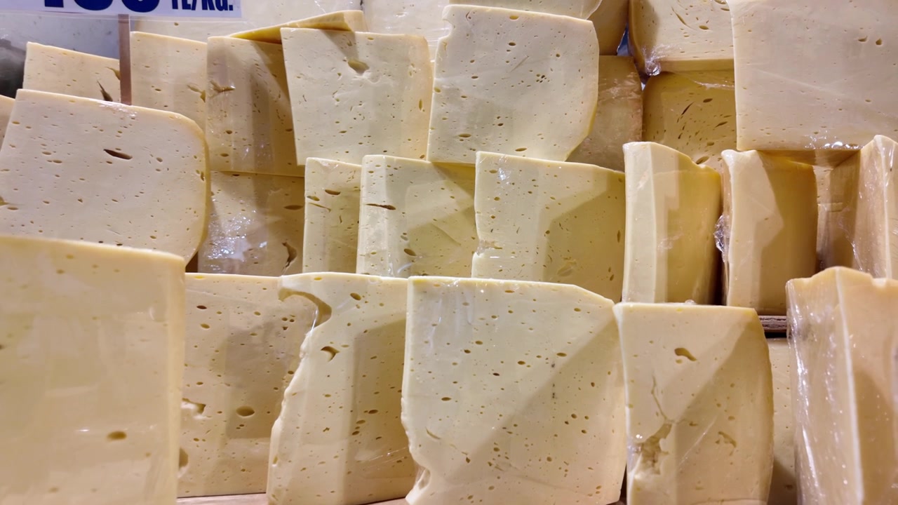 Stack of Fresh Yellow Cheese Blocks in a Market