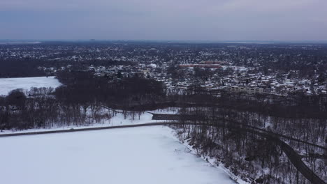 an aerial view from a drone, over a long lake during sunrise on a cloudy morning