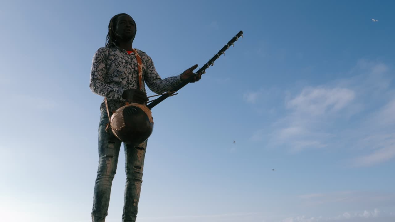 A Senegalese man plays a traditional kora string instrument. Traditional Afro African music often played in the streets, at weddings, and on festivals.