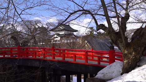 Vista-Manual-En-Cámara-Lenta-Del-Típico-Puente-Rojo-Frente-Al-Castillo-Japonés