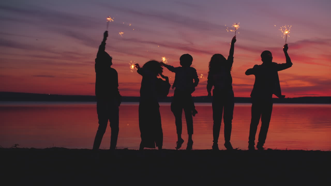 스파클러와 함께 해가 지는 것을 축하하는 친구들