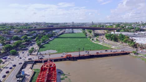 Luftaufnahme-Des-Ozama-Flusses-Mit-Invasiver-Seerose,-Autos-Fahren-Auf-Der-Matias-Ramon-Mella-Brücke-In-Ciudad-Colonial,-Santo-Domingo,-Dominikanische-Republik