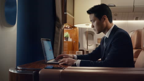 Businessman working on laptop during flight