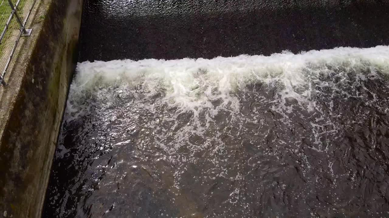 Aerial ascending shot over the small water dam on the Little Ouse river near Thetford in the UK
