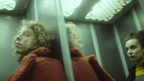 young women riding elevator