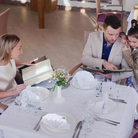 family read menus in restaurant