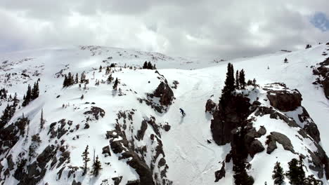 Travesía-En-Polvo-Snowboarder-Colorado-Montañas-Rocosas-Bajar-Corredor-Primavera-Aguanieve-Nieve-Fresca-Polvo-Aéreo-Cinematográfico-Dron-Parcialmente-Nublado-Clima-Piedra-Angular-Montezuma-Ciervo-Arroyo-Movimiento-Al-Revés