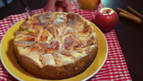 Slicing-freshly-baked-apple-pie-with-sharp-kitchen-knife