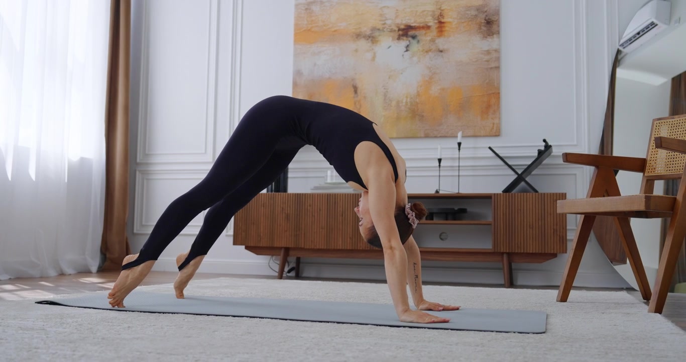 Junge Frau praktiziert Yoga-Posen auf der Matte zu Hause
