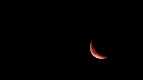 luna creciente brillante se levanta en la parte inferior derecha del cielo nocturno negro oscuro