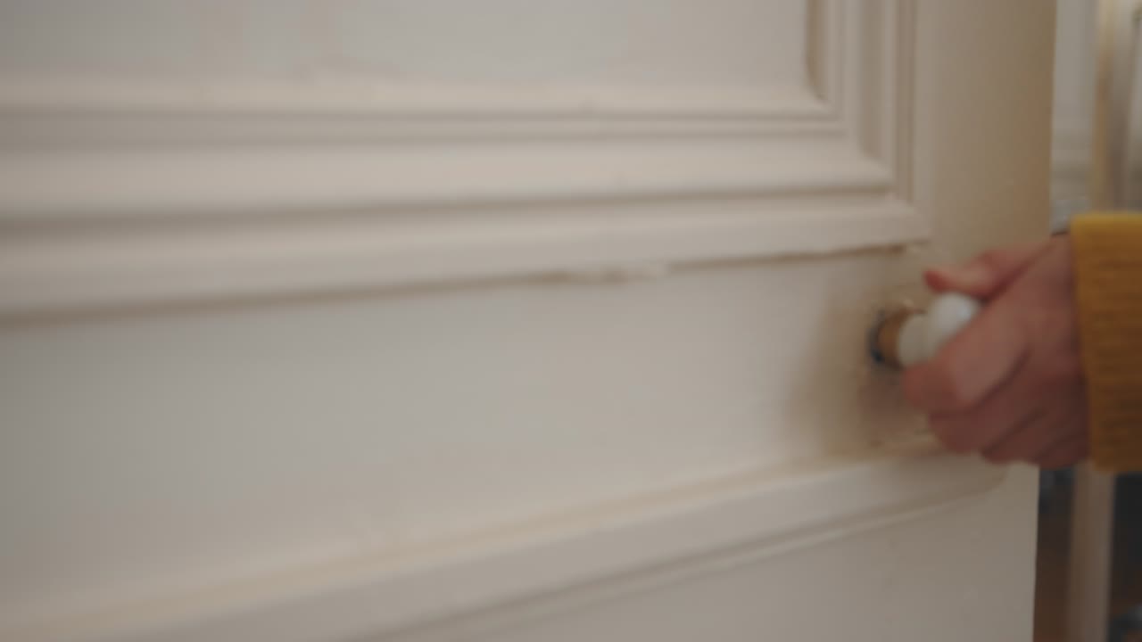 Hand of woman open old white color wardrobe with vintage handle