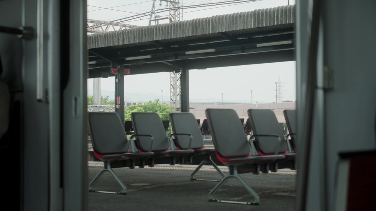 มุมมองจากภายในรถไฟใต้ดินขณะที่ประตูรถไฟกำลังปิดบนที่นั่งว่างเปล่าบนชานชาลาในสถานีรถไฟในเมืองโอซาก้า
