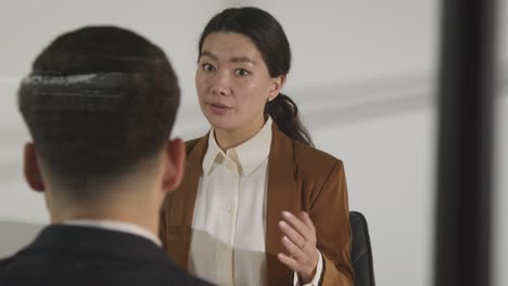 창 3을 통해 본 여성 면접관이 취업을 위해 사무실에서 남성 후보자를 인터뷰하고 있습니다.