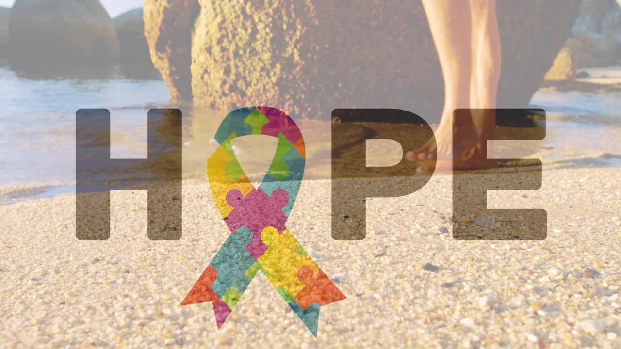 Colorful puzzle ribbon forming word HOPE over beach with rocks and sand
