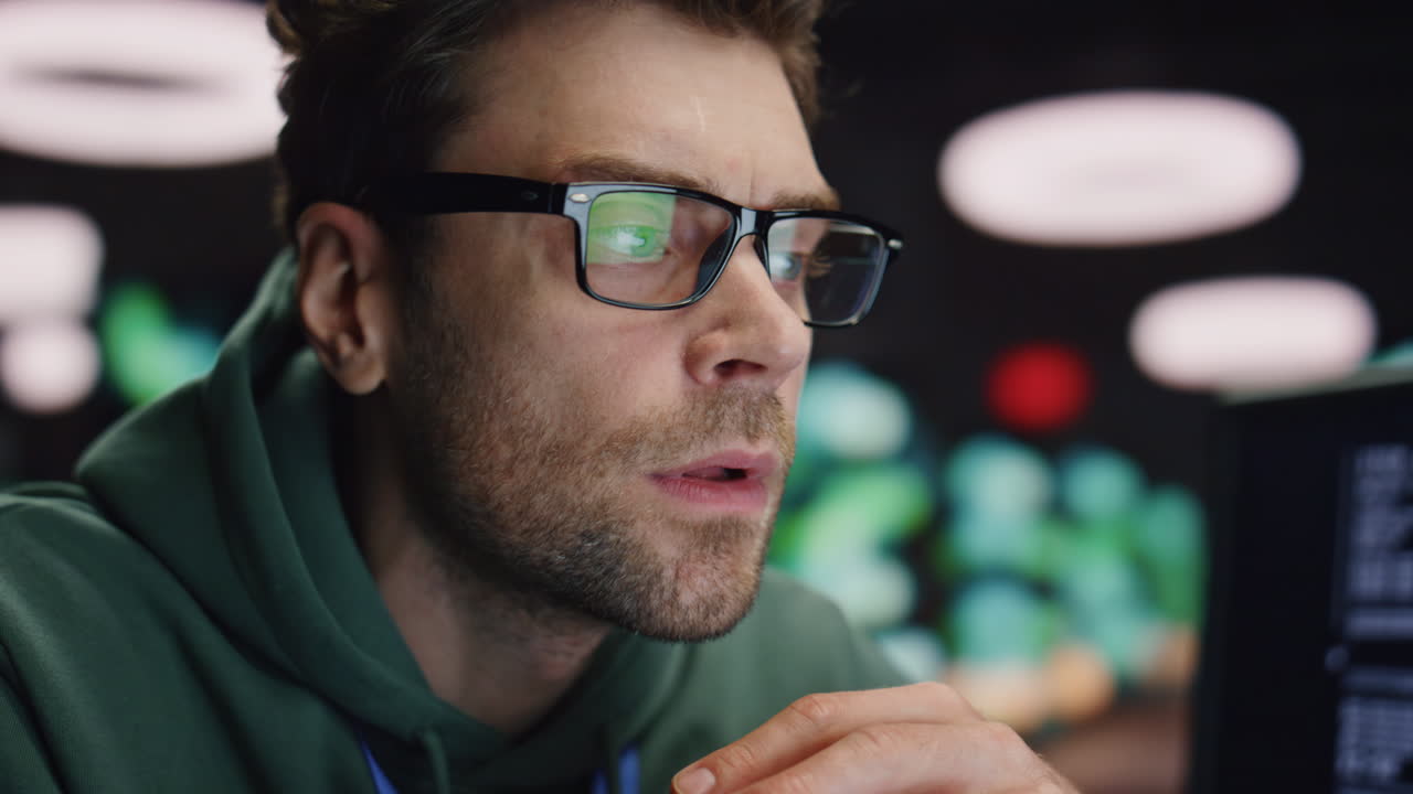 desarrollador serio de primer plano trabajando en el centro de datos de noche. hombre cansado encontró error