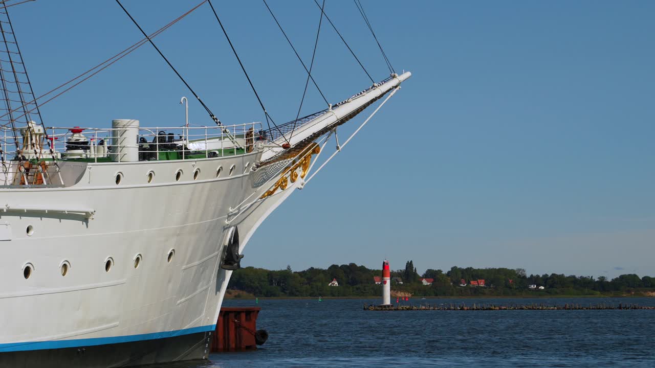 bow of large sailing boat with pier lights in the background at the harbor