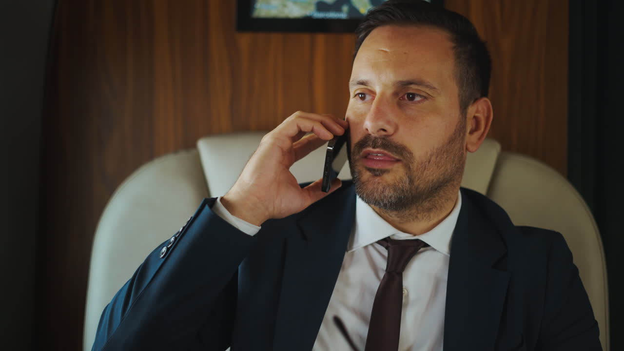 Podnikatel hovoří po telefonu v soukromém tryskáči