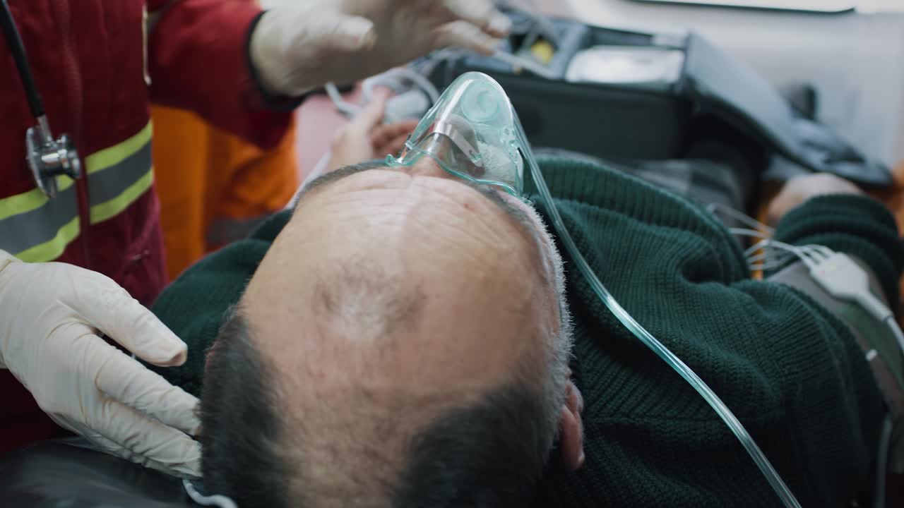 crop Doctor Putting Oxygen Mask on Unconscious Man Anonymous Paramedic Putting Oxygen Mask on Unconscious Aged Patient while Working in 911 Service Vehicle during Emergency