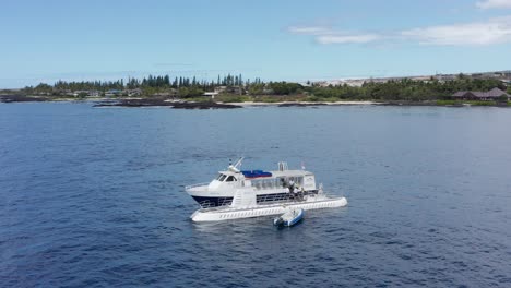 low panning aerial shot of people boarding a submarine off the shores of kailua-kona on the island of hawai'i