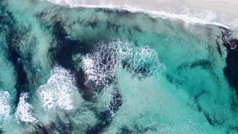 Draufsicht-Des-Türkisfarbenen-Ozeans-Mit-Wellen,-Die-Einen-Einsamen-Strandschutz-Freigeben