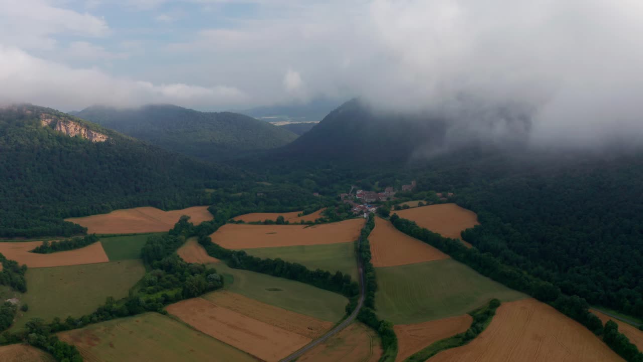 campos agrícolas cerca de las montañas bajo un cielo nublado azul