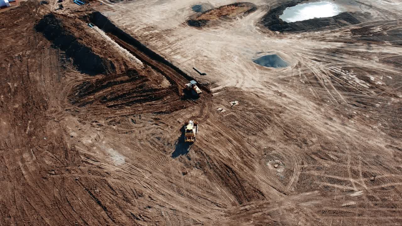 Two bulldozers are digging at a construction site in Calgary