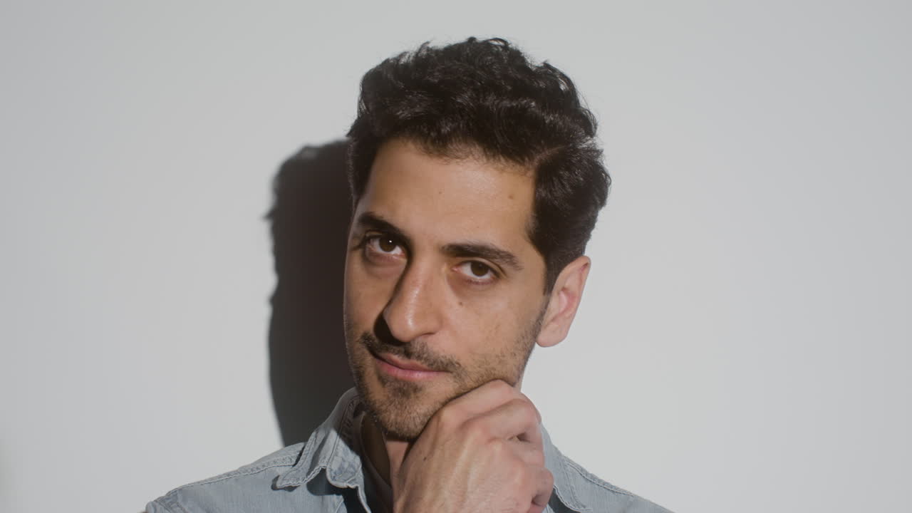 hay un hombre atractivo tocándose la barbilla y la barba