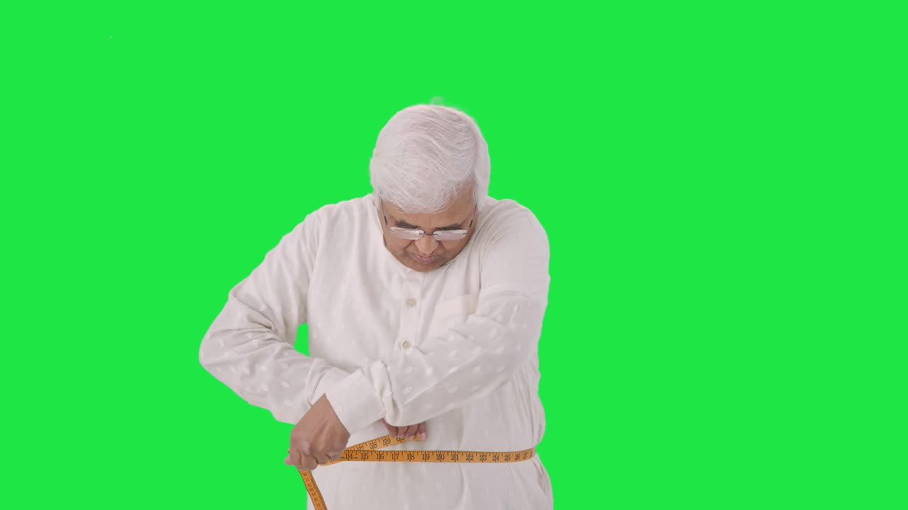 viejo indio midiendo la cintura usando cinta de pulgada pantalla verde