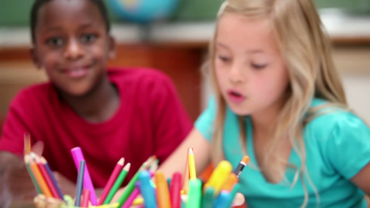 alumnos sentados detrás de bolígrafos para colorear