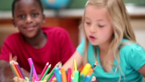 pupils sitting behind coloring pens