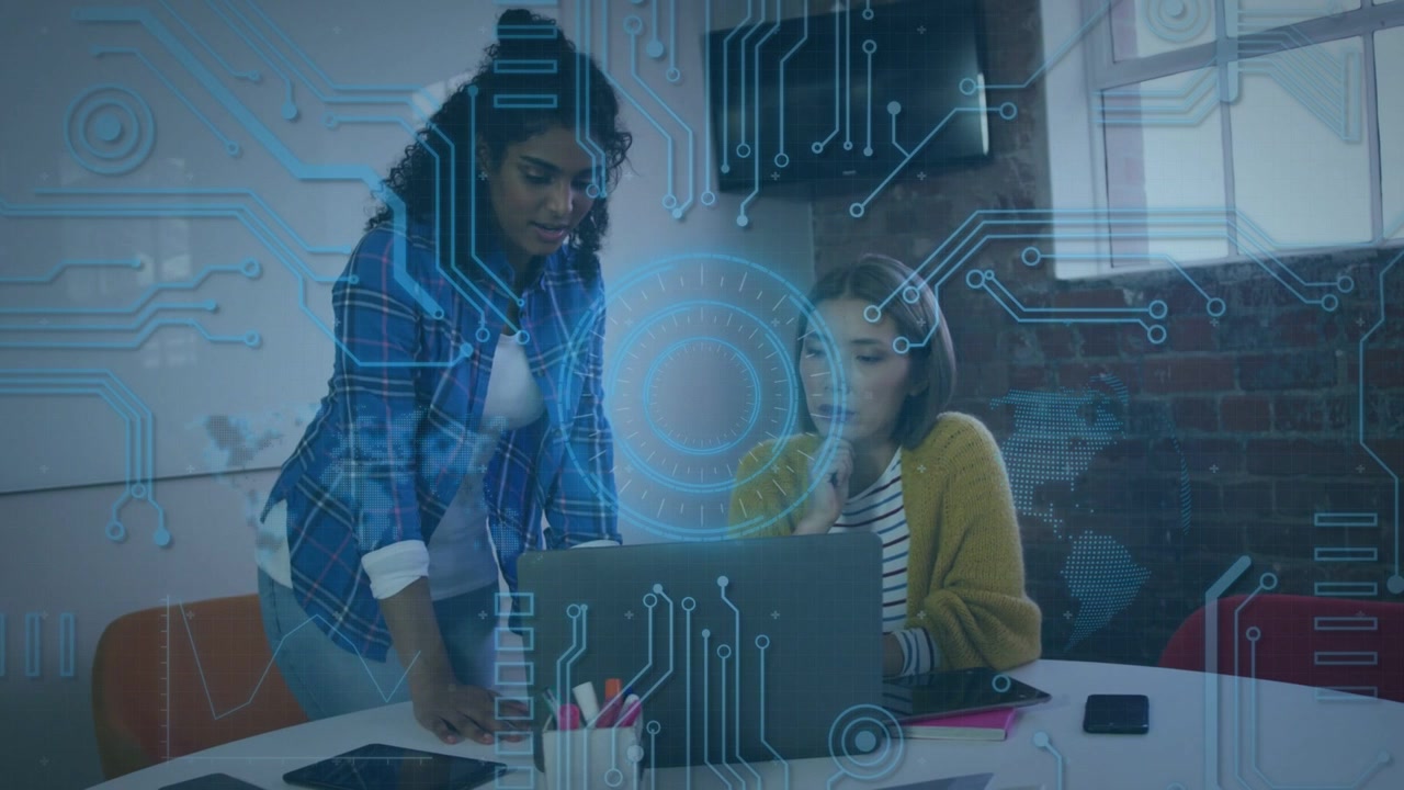 Lead leaning and pointing at laptop, peer seated reviewing business data, circuit overlay appearing