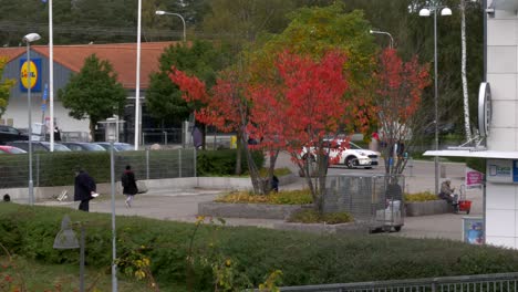 Gothenburg,SWEDEN-NOVEMBER-30-2021:-A-beautiful-sidewalk-with-people-walking-and-a-Lidl-sign-in-the-background-on-top-of-a-gas-station