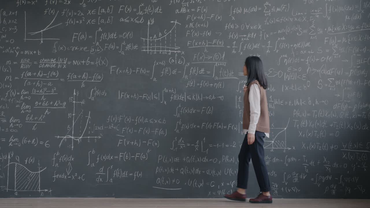 Student working on math equations on a blackboard