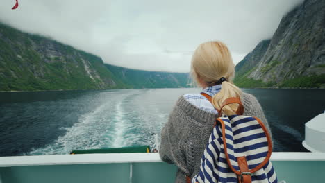 Mujer-Turista-Admirando-El-Pintoresco-Fiordo-Noruego-Desde-La-Popa-De-Un-Crucero