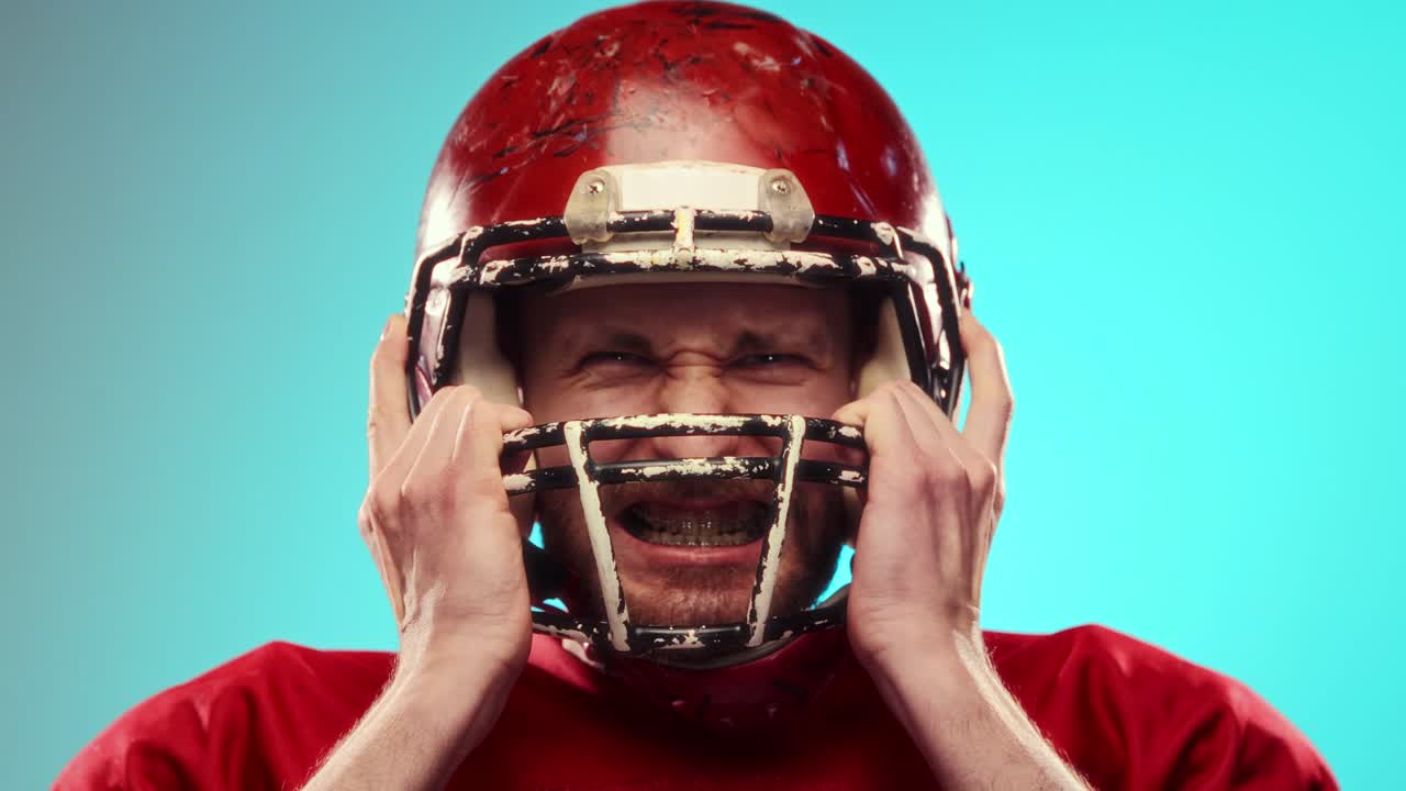 Giocatore di football arrabbiato che si sistema il casco