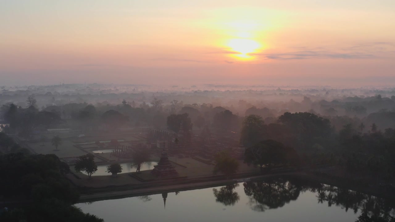 Vista aerea sul Parco Storico di Sukhothai in Thailandia con laghi e templi nella nebbia all'alba