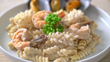 spiral pasta mushroom cream sauce with seafood - italian food style