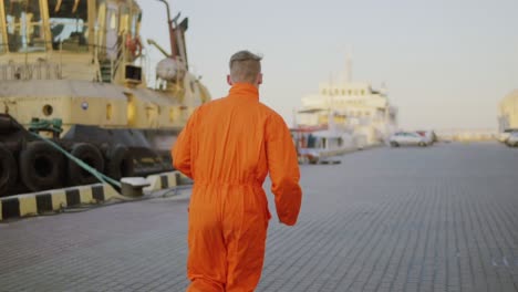 Arbeiter-In-Orangefarbener-Uniform-Läuft-Im-Hafen