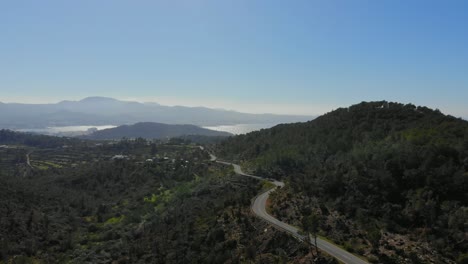 ibiza forward over road and hill with water in the background.
