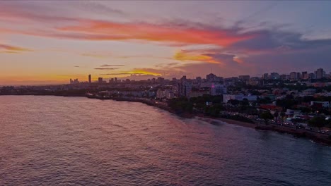 drone flying over sea waters of santo domingo malecon at twilight, dominican republic