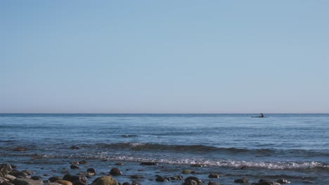 120-Fps-Beschleunigte-Aufnahmen-Vom-Strand-Mit-Einem-Mann-Auf-Einem-Paddelbrett-In-Der-Ferne