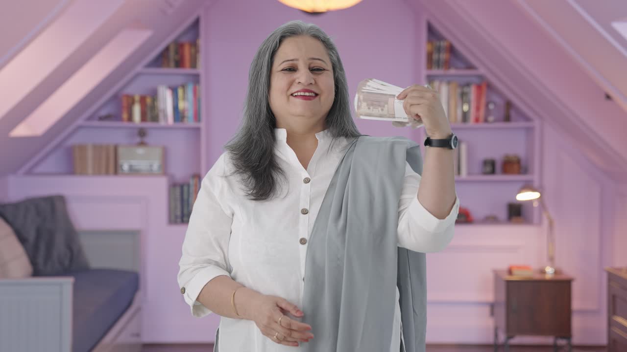madre india feliz usando el dinero como ventilador
