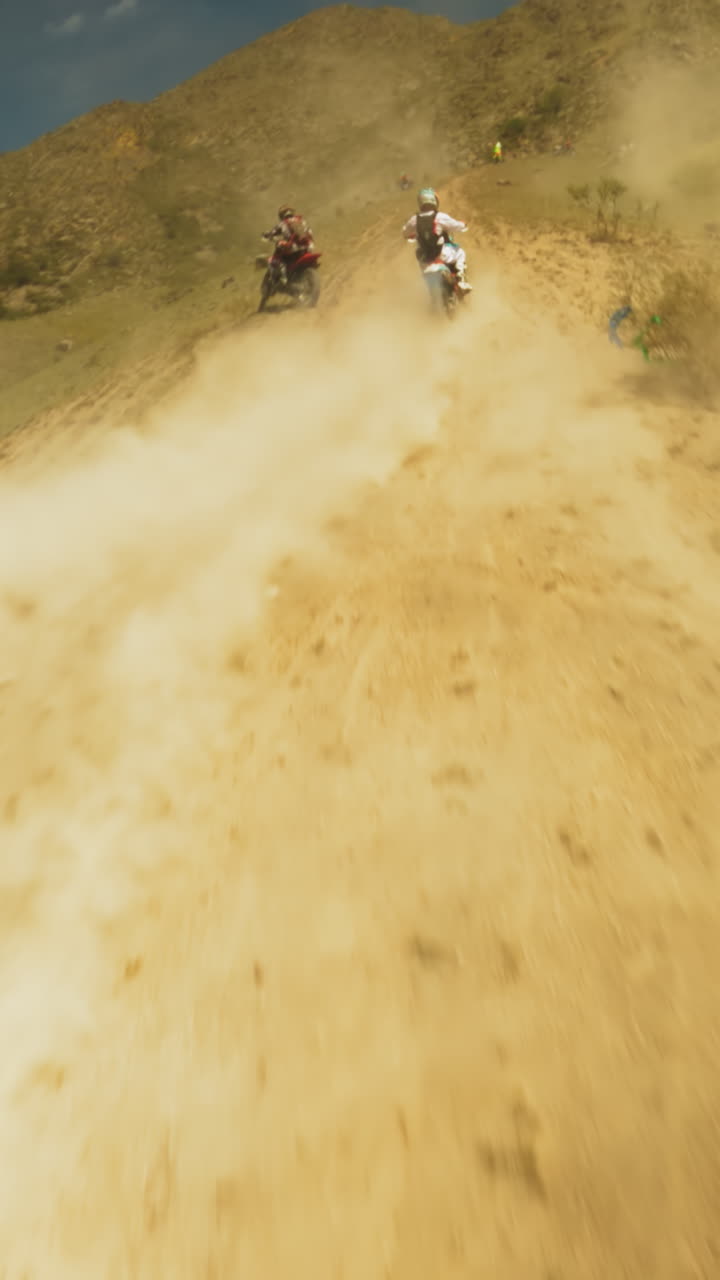 Participants navigates hollows with focus. Thrill of competition with eyes set on outpacing rivals in high-stakes sports moto-contest. Technical prowess
