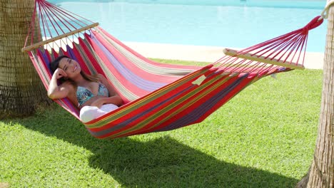 smiling young woman laying down in hammock