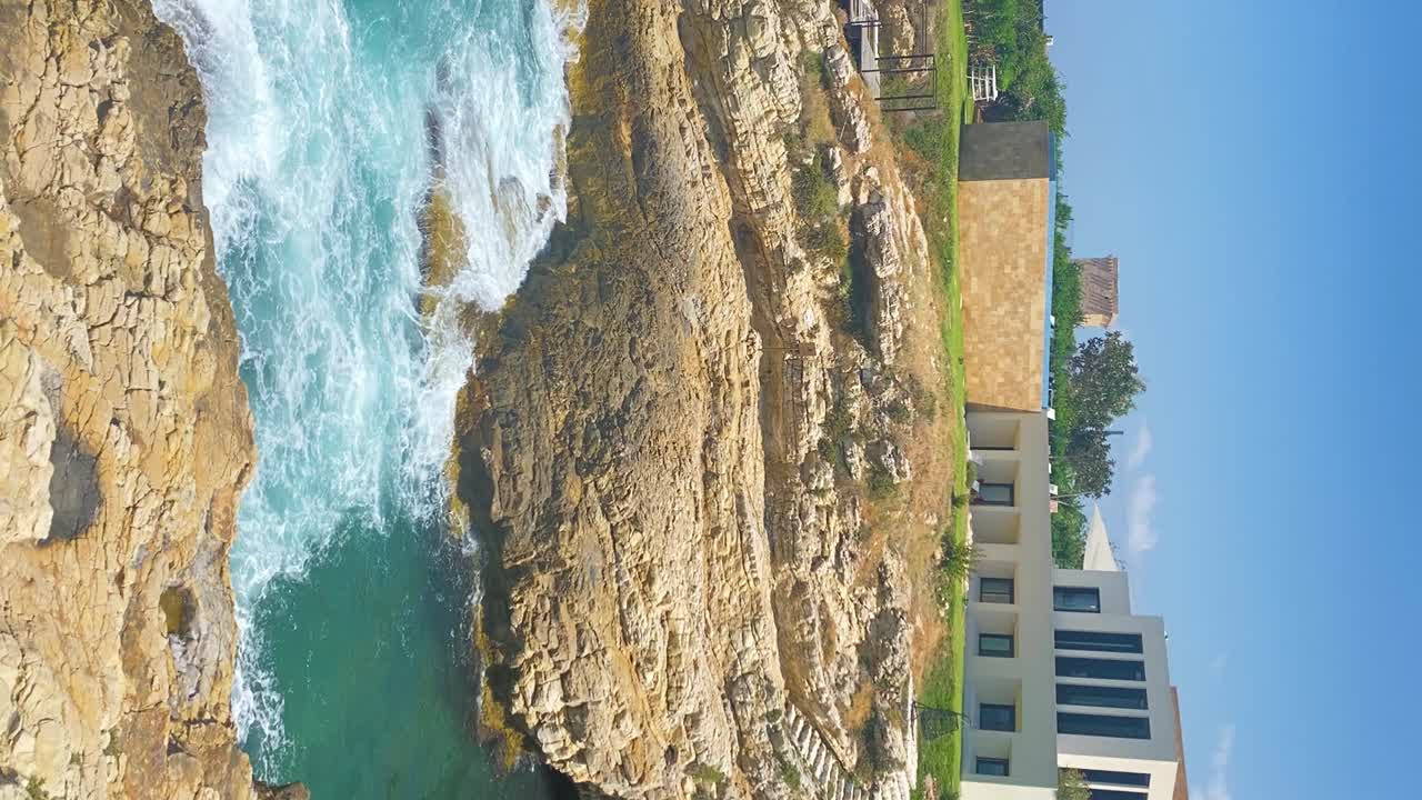 toma vertical de la costa rocosa en la lujosa residencia de fidar beach house en jbeil, líbano