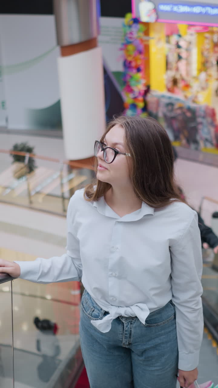 dama en la escalera mecánica ascendente en un gran centro comercial, mirando a su alrededor mientras está rodeada de otros compradores y coloridas exhibiciones de tiendas, capturando la animada atmósfera de las compras urbanas