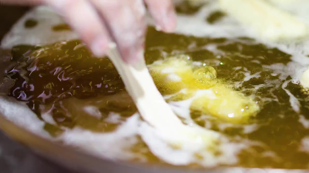 Chef Deep Frying Dough Strips in Hot Oil
