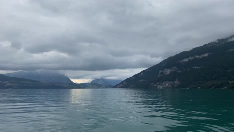 sailing on lake thun at sunset dramatic cloudscape, quiet evening scenery