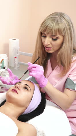 cleansing peeling at the beauty salon. face cosmetic procedure. beautiful woman in a spa vertical video