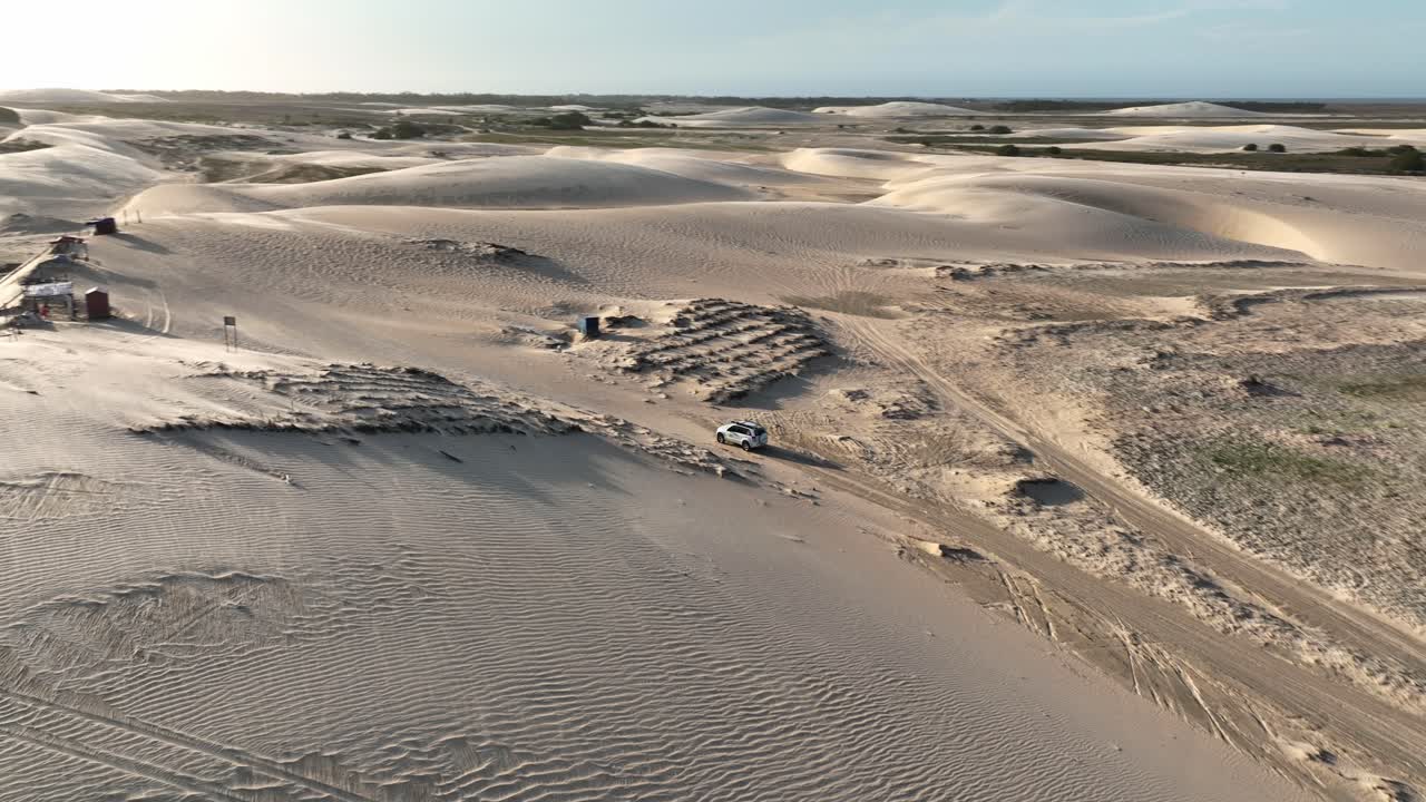 A vehicle traverses vast sand dunes in Lençóis Maranhenses National Park, Brazil